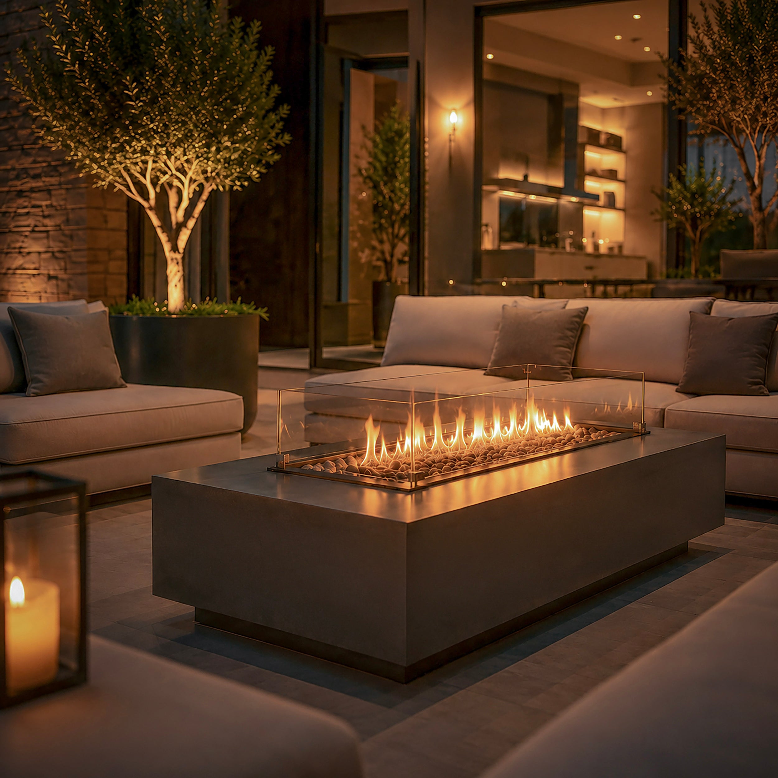 Aurora Flame luxe vuurtafel als sfeervol middelpunt van een moderne loungehoek met comfortabele buitenbanken en warme avondverlichting.