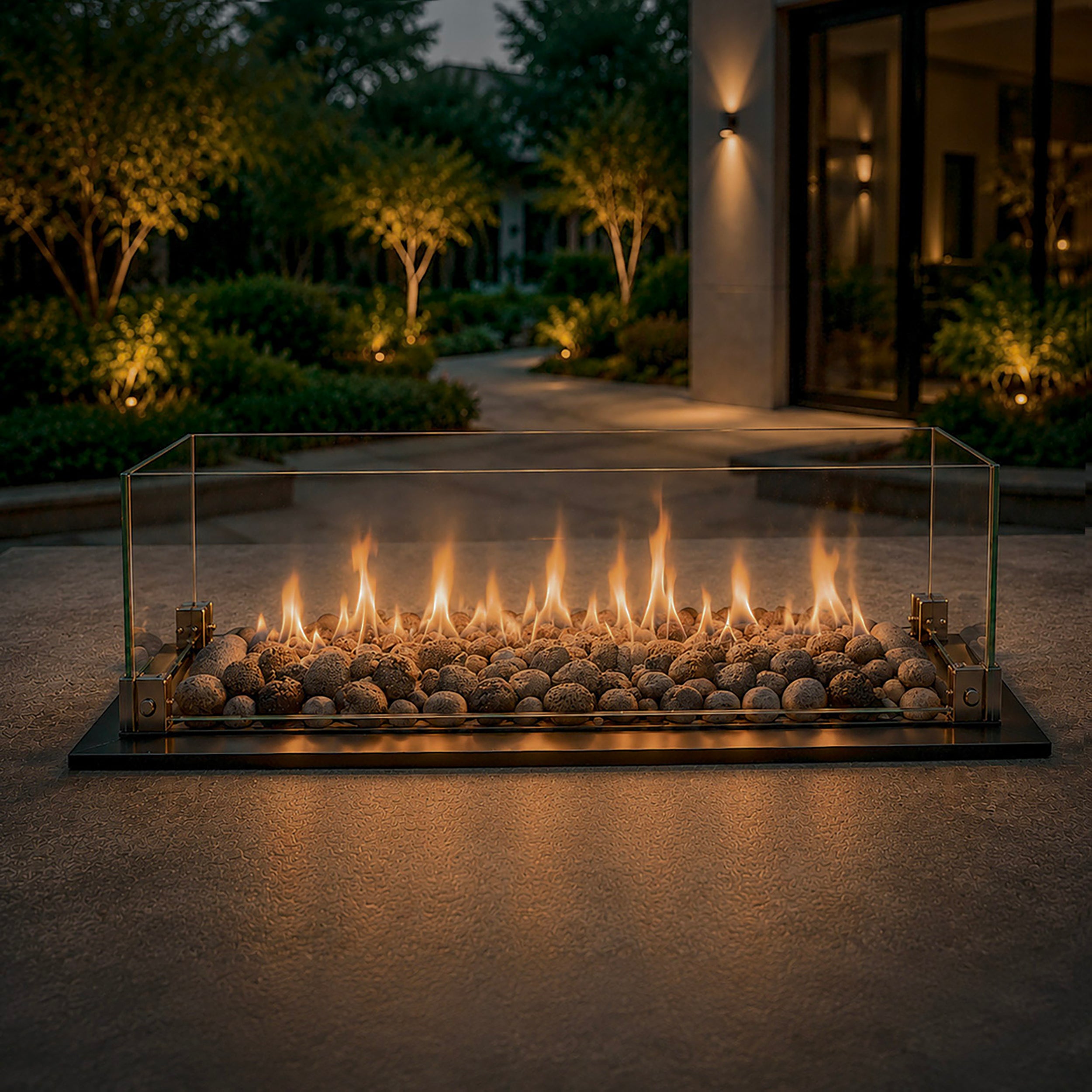 Detailfoto van de Aurora Flame vuurtafel met lineaire gasbrander, natuurstenen vulling en glazen windscherm in een moderne buitenruimte.